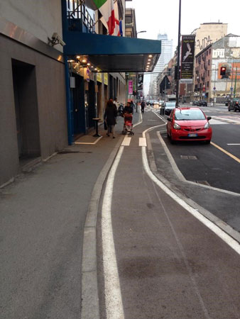 conflitto tra ciclisti e pedoni sul marciapiede davanti all'uscita di un cinema