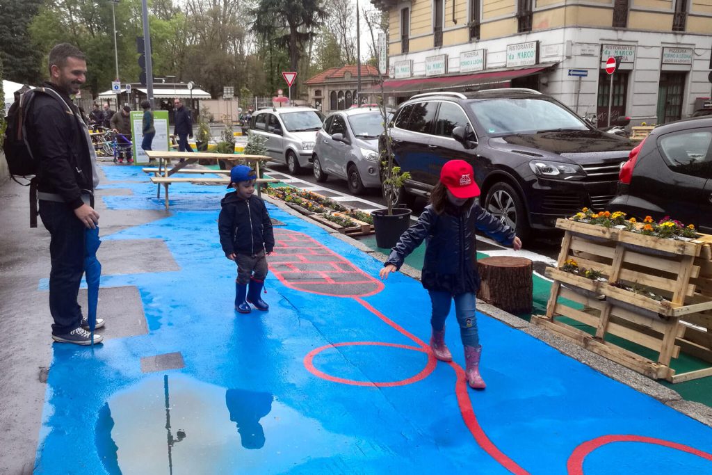 Sperimentazione di una zona 30 a Milano quartiere Rovereto:: i bambini giocano sul marciapiede liberato dalle auto in divieto di sosta