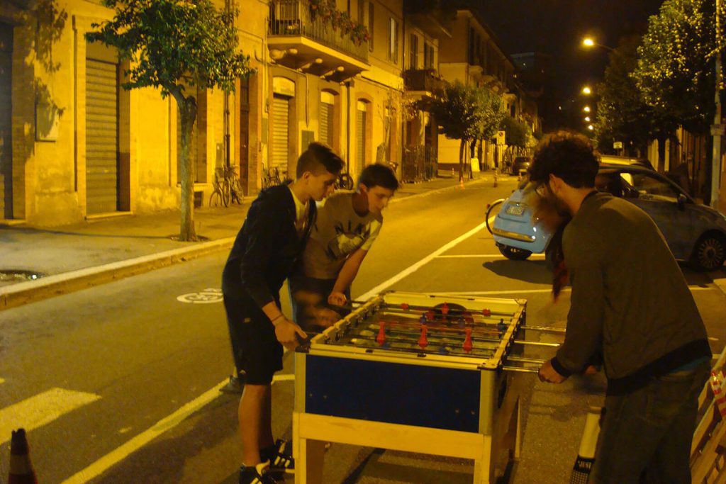 Sperimentazione di via Montegrappa a Terni: ragazzi che giocano a calcio balilla dove prima c'erano solo automobili